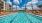 a swimming pool with lounge chairs and a building in the background